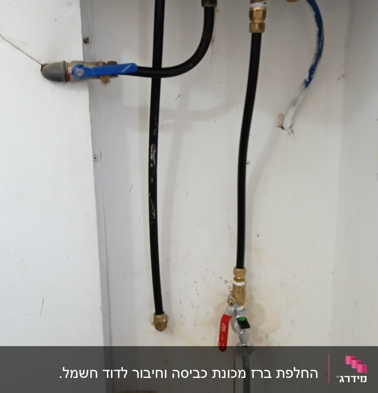 צינורות מים עם ברזים וחיבורים מתחת לכיור